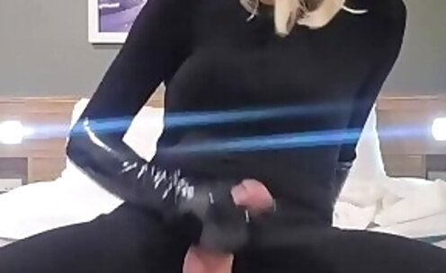 cumming wearing a catsuit and strapon harness